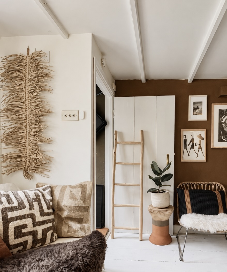 Warm living room with textured cushions, a wooden ladder and a leafy plant